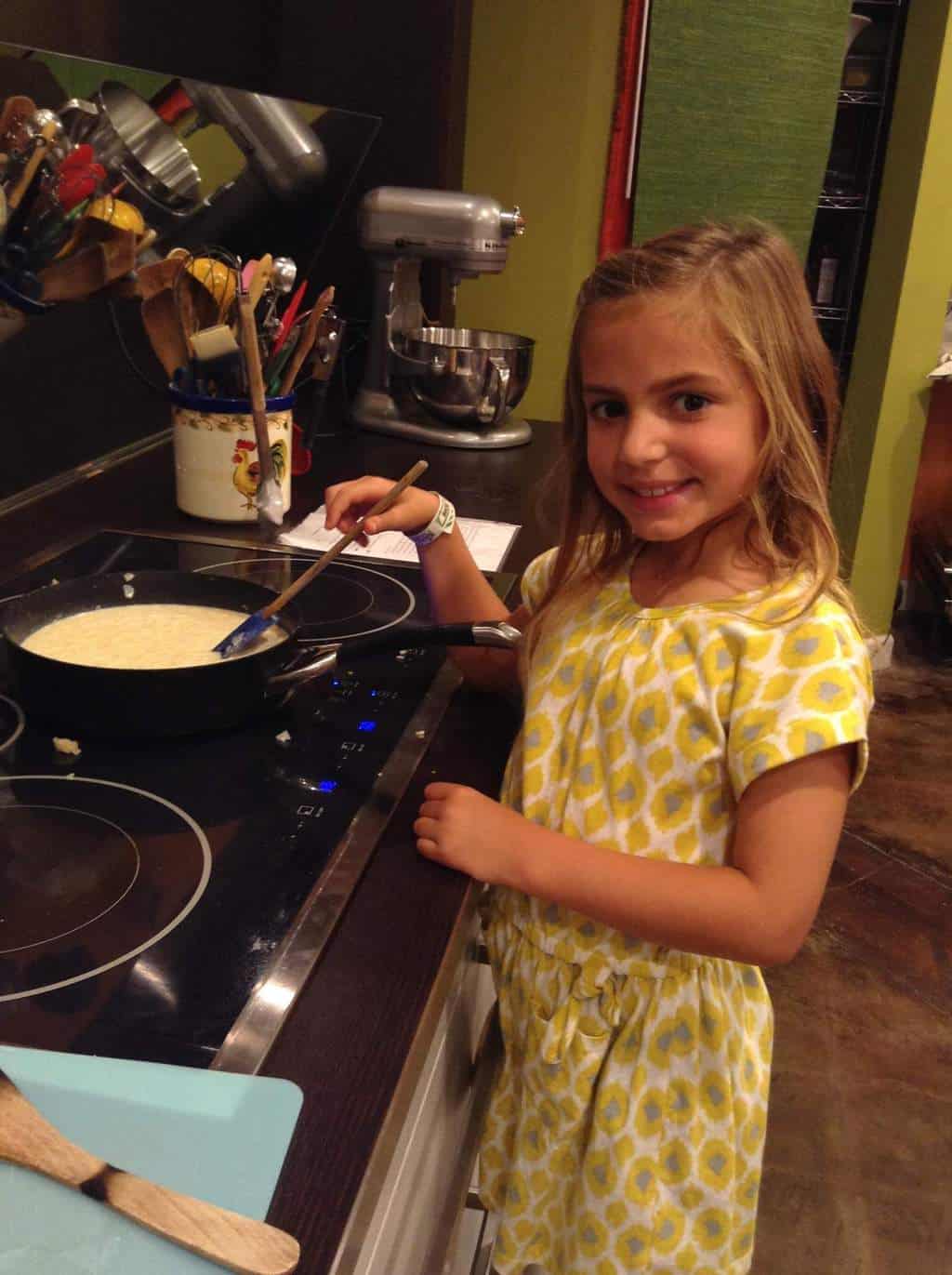 little girl stirring over stove