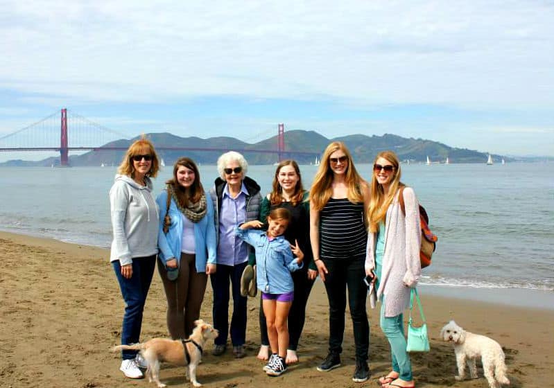 family on beach in front of golden gate bridge in san fransisco