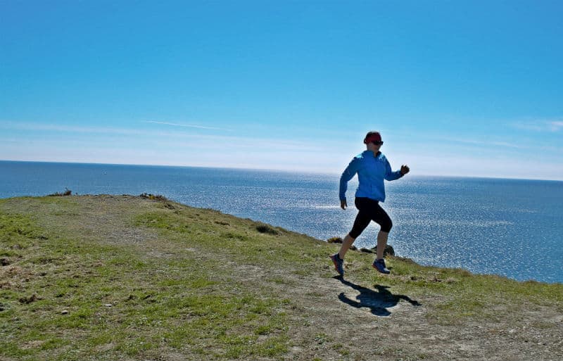 running along coastline near soar mill cove south devon by eileen cotter wright