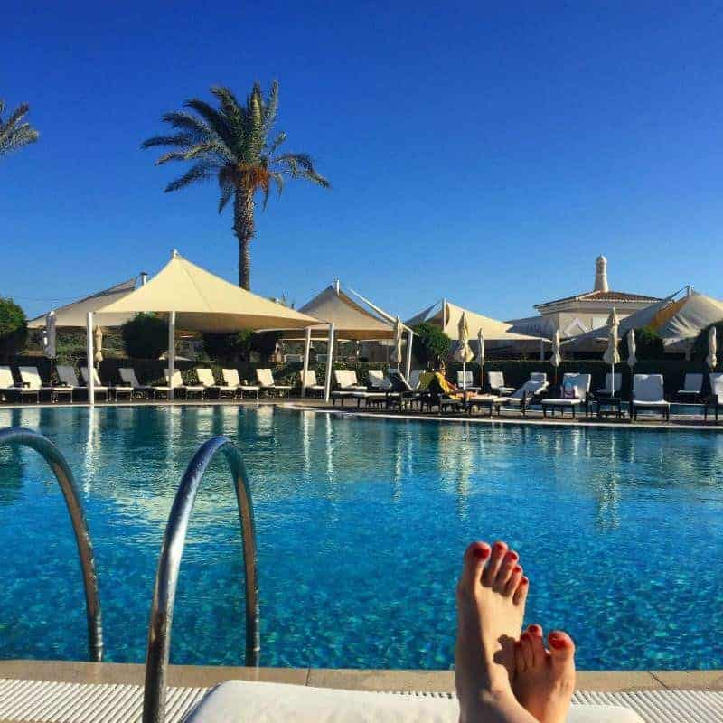 Blue skies laying by pool palm trees