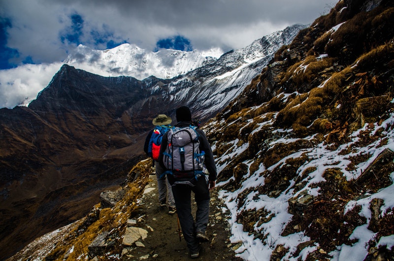 two people trekking in nepal mountains with snow